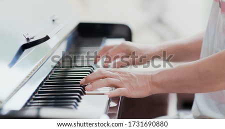 close up of asian old man practice playing the piano at home