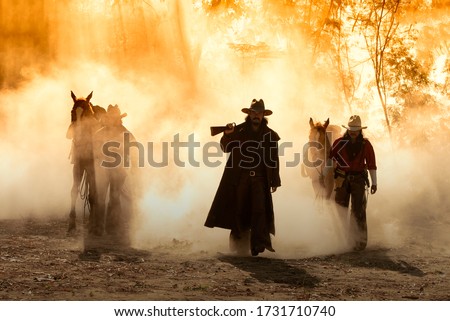 Portrait western cowboys riding horses, roping wild horses in Mexico and America.Smoke background.