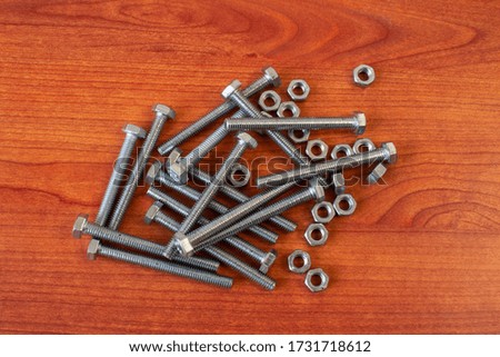 Photos bolts, nuts, screws on the wooden background