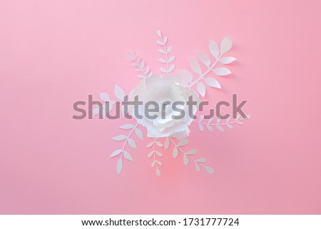 Handmade paper art and cutout white flower on pink background. 