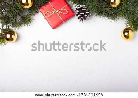 Background for the New Year, Christmas. Christmas toys and conifer branches. Gift in red paper, white cone. Place for text.
