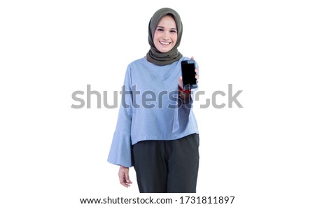 Beautiful hijab woman is holding a smart phone and showing it to the camera