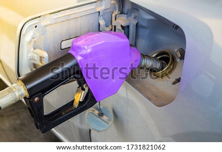 
Purple fuel nozzle refueling a gasoline at gas station. Royalty-Free Stock Photo #1731821062