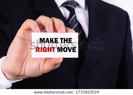 Businessman shows a sign with the text MAKE THE RIGHT MOVE. Business concept