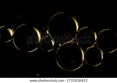 A macro photograph of water droplets on oil