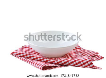 White bowl on red checkered cloth folded towel isolated.Food advertisement display.