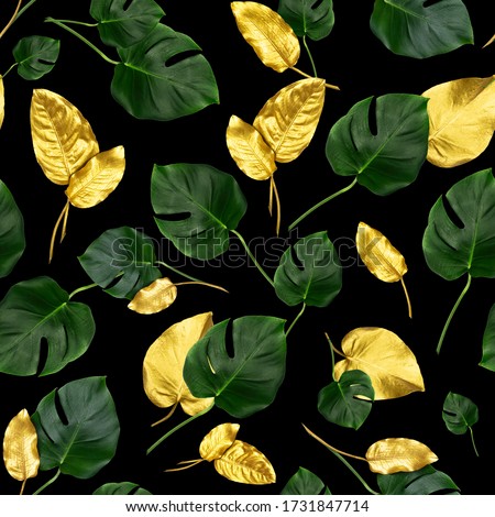 Golden and green tropical leaves on black. Tropical seamless pattern. 