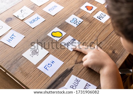 Little kid playing with cards of words and pictures. Time to learn. Education concept.