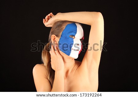 Football fan with face painted in France color on black background 