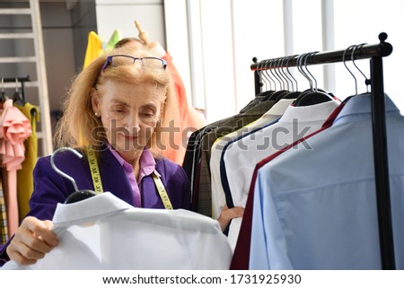 The tailor's business owner is choosing clothes so customers can decide to order tailors for her shop.