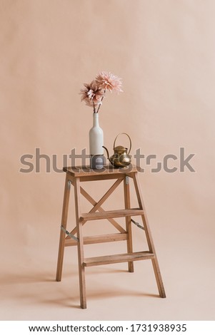 Artificial flowers in a vase. Studio photography of flowers. Decorative flowers with own hands. A minimalist bouquet of artificial flowers 