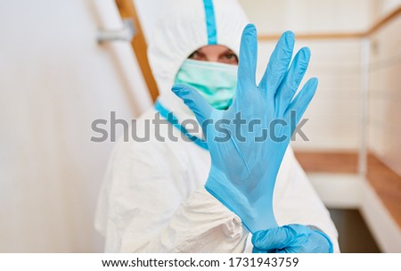 Nurses or medical professionals wearing protective clothing put on new disposable gloves during the Covid-19 epidemic