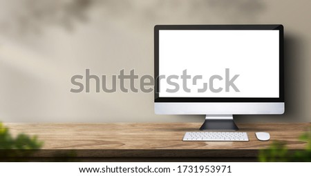 desktop computer on wood table backgorund with sunlight window create leaf shadow on wall with blur indoor green plant foreground.panoramic banner mockup for display of product.3d rendering