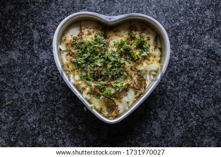 gujarati delicacy dhokla prepared in a heart shaped bowl with gray granite background