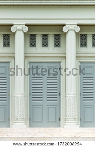 Beautiful ancient green wooden door shutters and detail of the romanesque columns Gothic architecture pole exterior vintage old building 