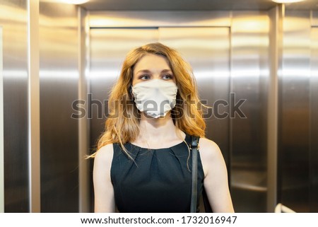 Business woman is using elevator during epidemic