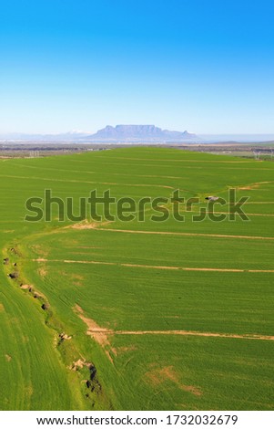 Aerial photo of green fields near Malmesbury with Table Mountain in the background