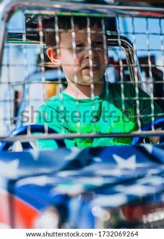 Beautiful boy having fun on the amusement rides at the local theme park