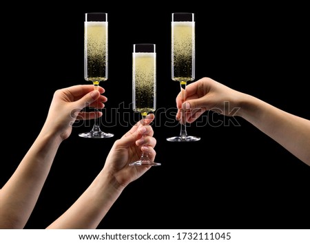 Set of hands olding glass of sparkling champagne isolated on black background.