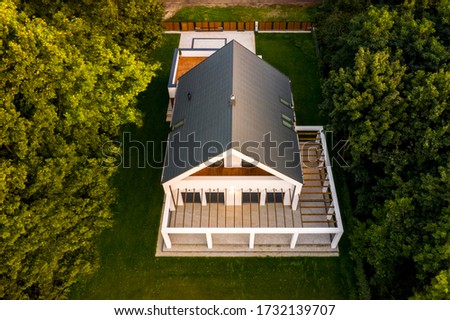 Aerial view of elegant home with designed veranda and big garden