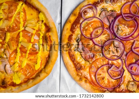 two pizzas with meat, mushroom, pineapple, tomato, onion. Traditional pastry for party, Selective focus