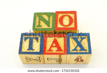 The term no tax displayed visually on a clear background using colored wooden toy blocks image in horizontal format with copy space