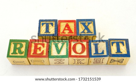 The term tax revolt displayed visually on a clear background using colored wooden toy blocks image in horizontal format with copy space
