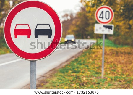 Car on the forest road on autumn day.  Road signs marks various rules.