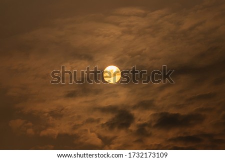 Beautiful background images of the morning sun, circling the orange sky with thick clouds.
