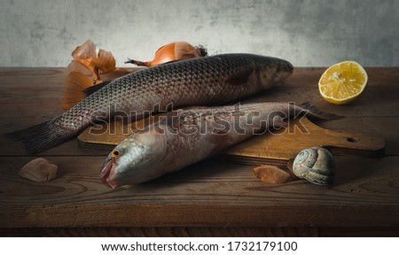 still life with fresh fish with onion and lemon