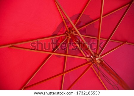 close - up view from below of a red beach umbrella