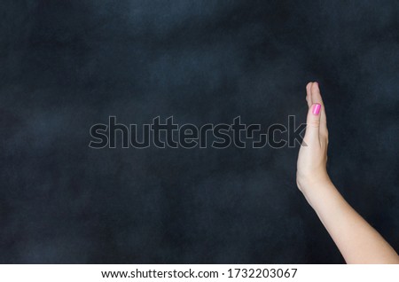 Woman making no or stop hand gesture signal or sign isolated on black