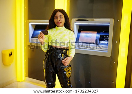 African american woman hold credit card after withdrawing money from a cash machine, ATM concept.