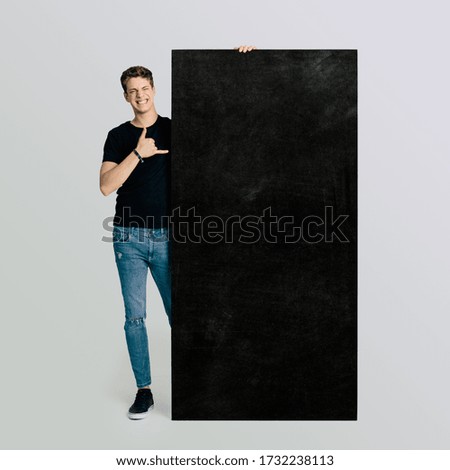 Young boy with colleague gesture on an isolated white background shows a customizable advertising poster with text. Space for text, customizable text.