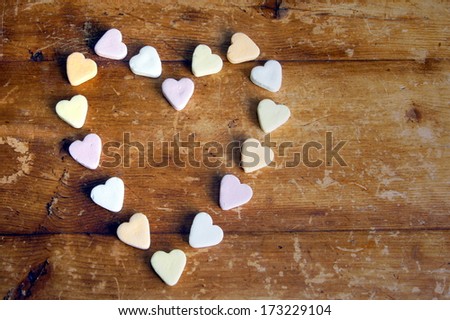 heart shape from little candy hearts on a wooden background 