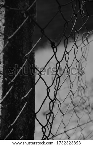 Wire fence post in black and white showing pattern