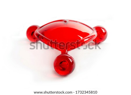 Red plastic body massager on white background
