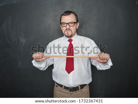 Angry business man or teacher with pointer on blackboard background Royalty-Free Stock Photo #1732367431