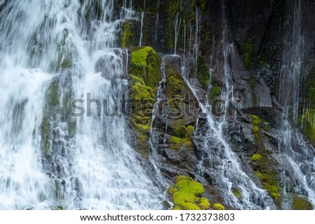 Landscape of waterfall on moss-covered stone hill 