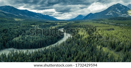 Beautiful and dramatic view towards mountains, a river and wild forrest. 