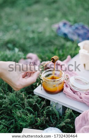 female hands hold a spoon in caramel. garden picnic birthday celebration