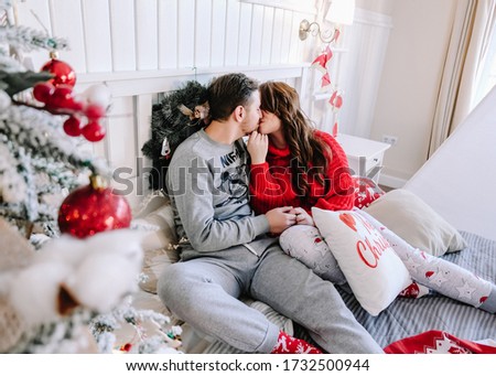 cute family couple in a new year interior with a Christmas tree and their favorite red dog Akita inu
