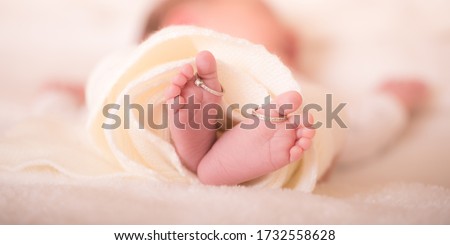 Babies foot taken closeup with two rings. Closeup of newborn baby feet with wedding rings. The concept of the family. Royalty-Free Stock Photo #1732558628