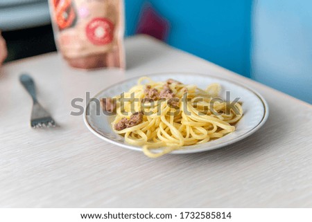 Spaghetti, Navy macaroni on a white plate on the table in the home kitchen.