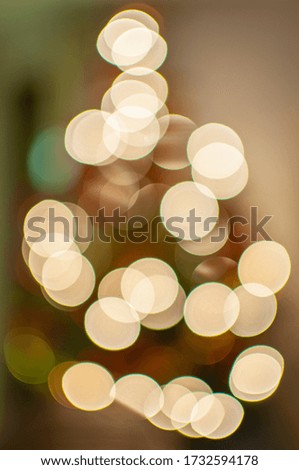 Christmas theme abstract image with blurred light circles from the christmas tree in warm tone. Christmas background and texture bokeh.