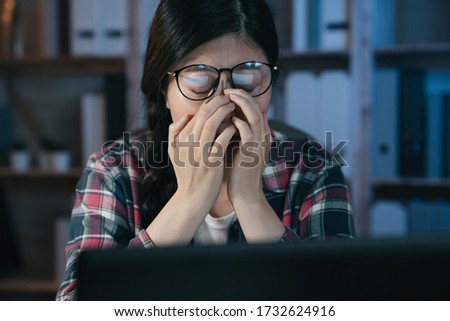 Exhausted asian korean female student studying online with laptop computer suffering eyestrain in night at home. tired stressed young college girl massage nose bridge while feelingeyes painful. Royalty-Free Stock Photo #1732624916