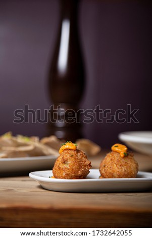 Cod fritters, traditional Spanish tapas on wooden table. Isolated image. vertical image