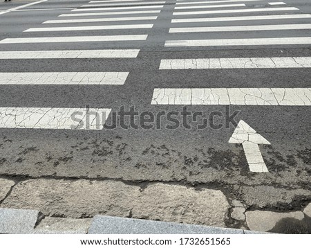 A white crosswalk on the asphalt way