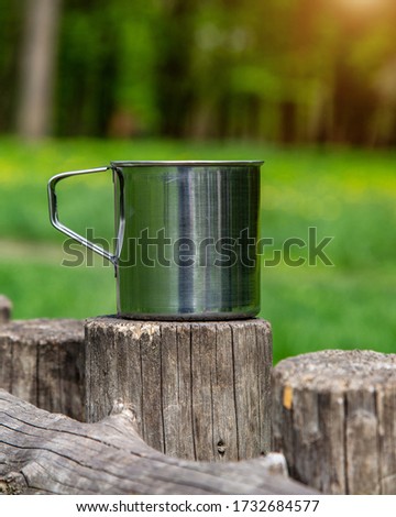 Tourist steel cup in the summer forest outdoors