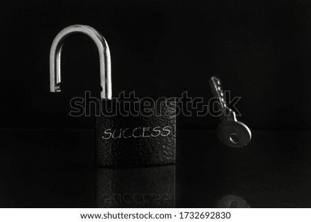 Motivational concept, development concept, business success. On a dark background, an open lock with "success"written on it. A key falls next to the lock.